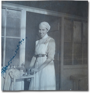 photo of Mina Mowat in a nurse uniform pushing a cart, captioned &ldquo;Operating room at Moore Barracks, &lsquo;Mowie&rsquo; in charge 1915&rdquo;